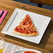 A square ivory porcelain flat plate with a slice of pepperoni pizza on it.
