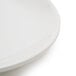 A close up of a Tuxton Healthcare Eggshell China plate with a small rim.
