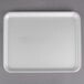 A white CKF foam meat tray on a gray surface.