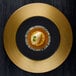 A black RAK Porcelain plate with gold embossed design holding food.