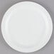 A white Cambro polycarbonate plate with a narrow rim on a gray surface.