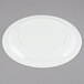 A white Cambro polycarbonate plate with a narrow rim on a gray surface.