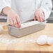 A person making bread in a Chicago Metallic aluminized steel bread loaf pan.