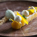 A dessert on a RAK Porcelain Oak Brown Woodart deep coupe plate on a wooden table.