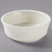 A white Tuxton china bowl with a small rim on a gray surface.