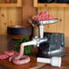 A Weston electric meat grinder with sausage being made by it.