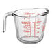 A clear glass Anchor Hocking measuring cup with a red handle and red measurements.