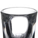 A close-up of a Libbey fluted shot glass filled with a clear liquid.