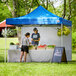 A man and woman standing in a blue Backyard Pro tent.