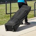 A man carrying a black Backyard Pro Courtyard Series canopy bag.