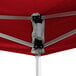 A close up of a red Backyard Pro Courtyard Series instant canopy with metal poles.