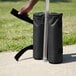 A person's hand holding a black Backyard Pro weight bag.