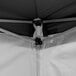 The corner of a black and white Backyard Pro canopy tent with black fabric.