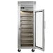 A Traulsen stainless steel wine refrigerator with a glass door open on a metal shelf.