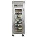A Traulsen stainless steel wine refrigerator with a full length glass door filled with wine bottles.