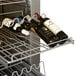 A Traulsen wine refrigerator with wine bottles in a rack.