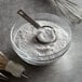 A measuring spoon in a bowl of white powder.