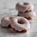 A group of donuts with white frosting on them.