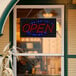 A rectangular LED sign that says "Open" hanging in a window.