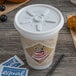 A Dart white foam cup with a lid on a table next to a bag of coffee.