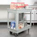 A gray Continental utility cart with food items on it.