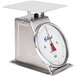 An Edlund stainless steel portion scale with a white dial on a counter.