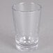 A close-up of a clear Carlisle SAN plastic shot glass.