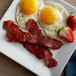 A plate of food with Godshall's turkey bacon, eggs, and strawberries.