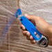 a hand holding a blue tool
