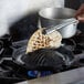 A person using tongs to cook a tortilla on a Thunder Group cast iron stovetop BBQ plate.