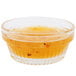 A Libbey Winchester glass ramekin filled with yellow liquid on a counter.