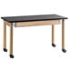 A black National Public Seating science lab table with oak legs and wheels.