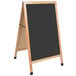 An Aarco oak A-frame sign board with a black chalk board.