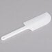 a white plastic knife on a gray background