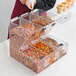 A woman using a Choice candy dispenser to pour candy into a container.