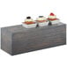 A Cal-Mil Ashwood gray oak wood rectangular riser with three cupcakes on it.