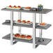 A Cal-Mil Ashwood three-tier riser with food on it on a display shelf.