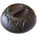 A black plastic dome with a handle and a hole on top over a plate.