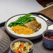 A Dinex underliner with a plate of food, green beans, pasta, and a bowl of berries on a hospital tray.