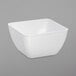 A white square Dinex bowl on a gray background.