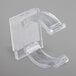 A close-up of a Snap Drape clear plastic table skirt clip with curved edges and holes.