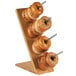 A Cal-Mil bamboo display stand holding four donuts.