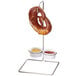A Cal-Mil wire rack holding a pretzel with two ramekins of sauce.