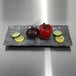 A rectangular Basalt melamine plate with vegetables and a lemon slice on it.