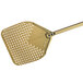 A gold rectangular pizza peel with holes in it.