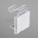 A close-up of a Snap Drape clear plastic table skirt clip with white hook and loop attachment.