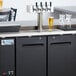 An Avantco black beer dispenser with two taps on a counter.