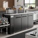 An Avantco UDD-72-HC Shallow Depth Kegerator with four beer taps on a counter in a bar.