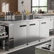 An Avantco stainless steel kegerator with three beer taps on a counter.