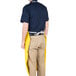 A man wearing a yellow San Jamar dishwasher apron.